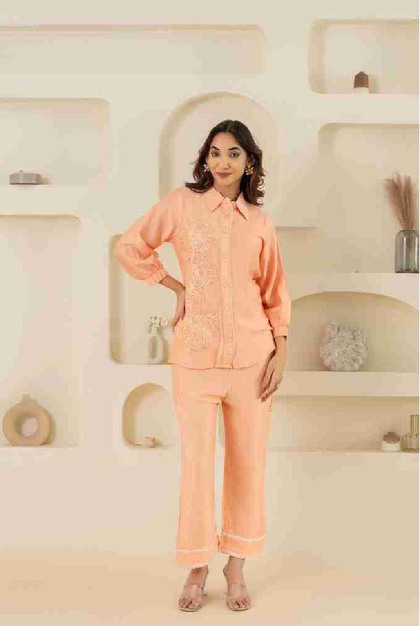 Woman wearing a peach-colored outfit in a decorated room.