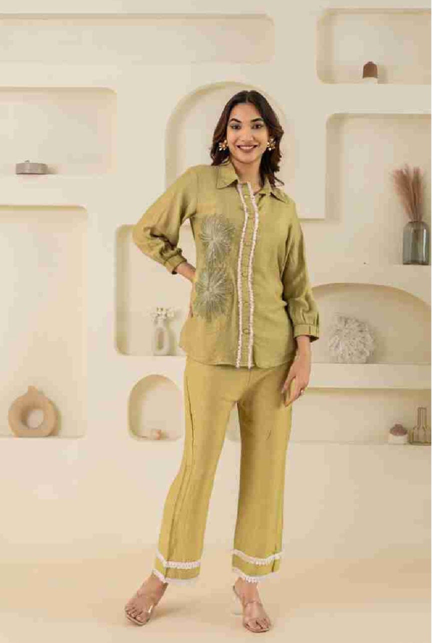 Woman wearing a green outfit with embroidery in a bathroom setting