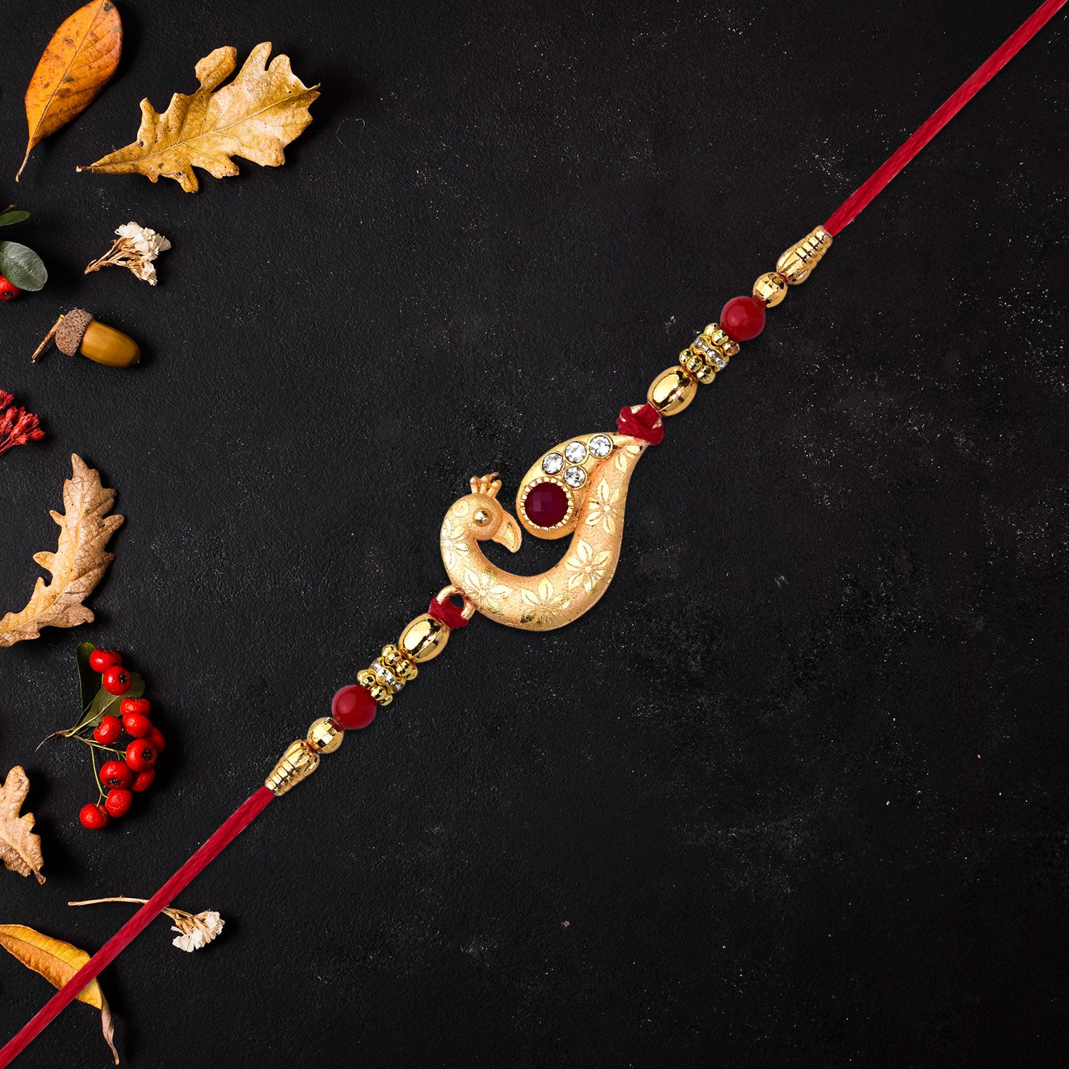 Golden Peacock Feather Rakhi With Red Thread And Kundan Detailing - warehousetech13
