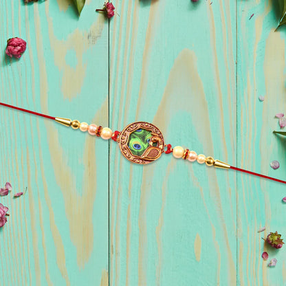 Elegant Rakhi With Peacock Feather Design And Pearl Bead Accents On Red Thread - warehousetech13