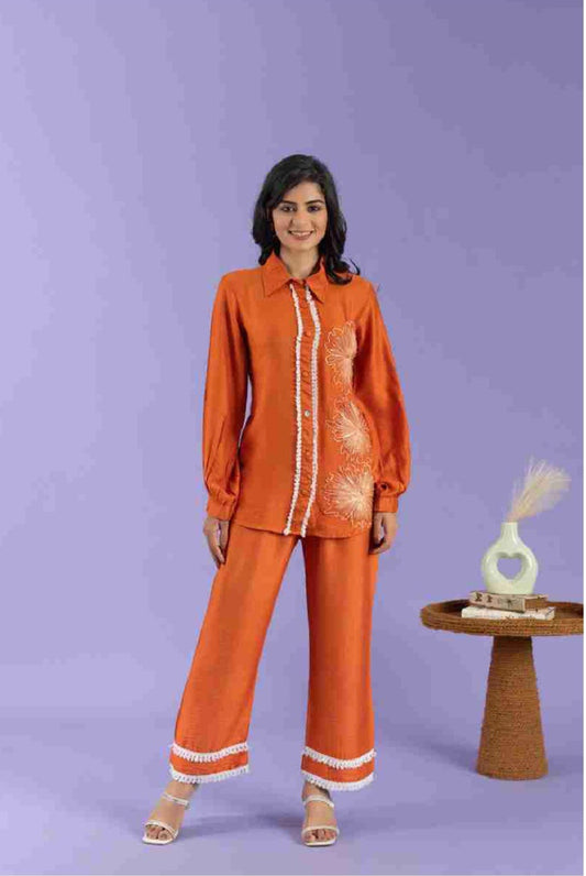 Woman wearing an orange outfit with white accents on a purple background