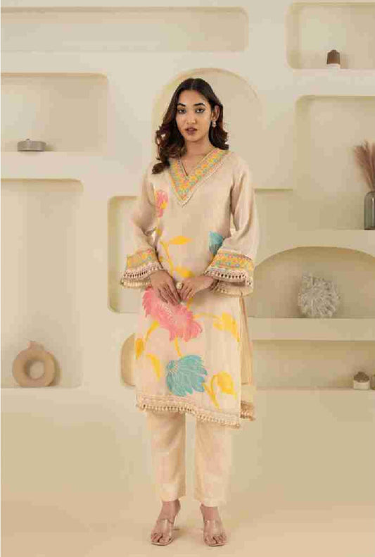 Woman wearing a traditional outfit with colorful patterns in a neutral setting